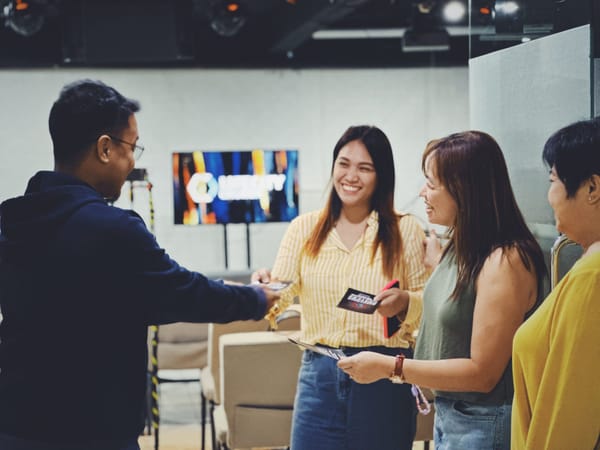 A small group of LifeCity members holding connection cards, smiling.